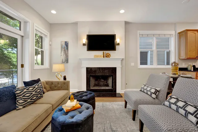a living room with furniture a flat screen tv and a fireplace
