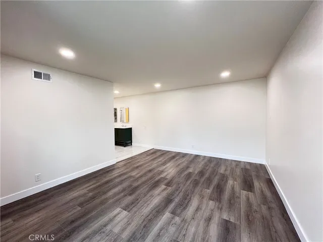 a view of empty room with wooden floor and fireplace