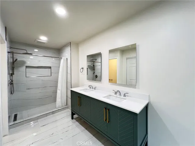 a bathroom with a sink shower and a mirror