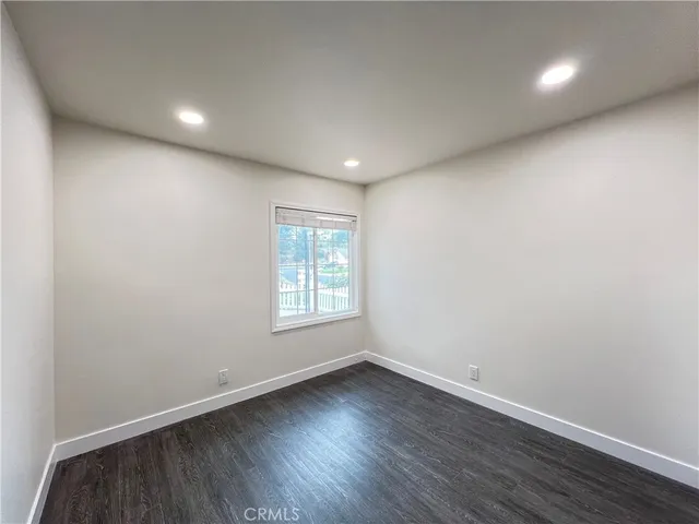 an empty room with wooden floor and window