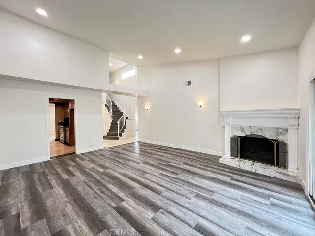 a view of empty room with wooden floor and fireplace