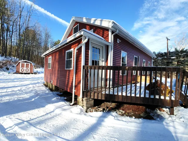 a view of a house with a wooden bench