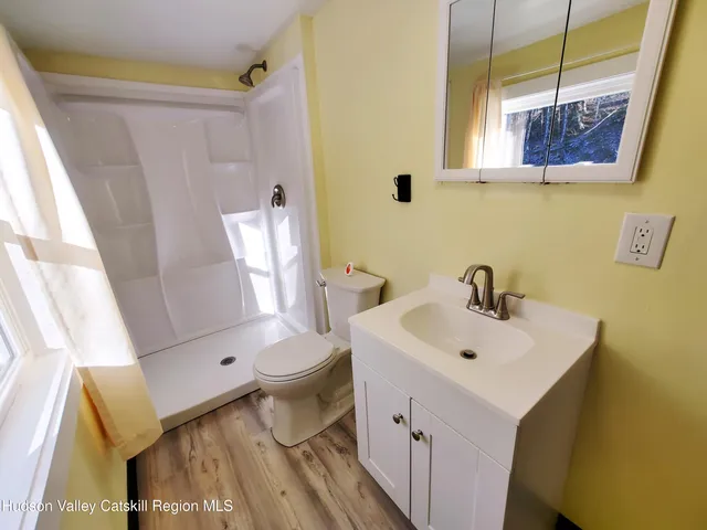a bathroom with a sink a toilet and shower