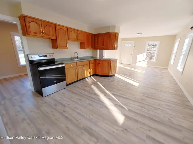 a kitchen with stainless steel appliances wooden floors and wooden cabinets