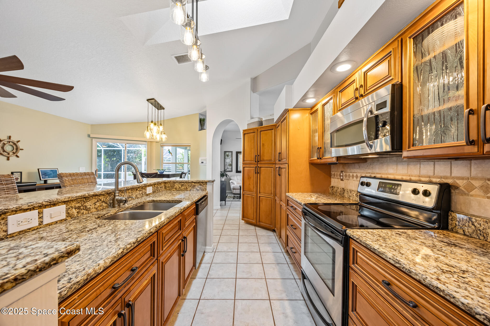 1252 Winding Meadows Road Rockledge, FL 32955 - Photo 13 of 32 a kitchen with stainless steel appliances granite countertop a sink and stove