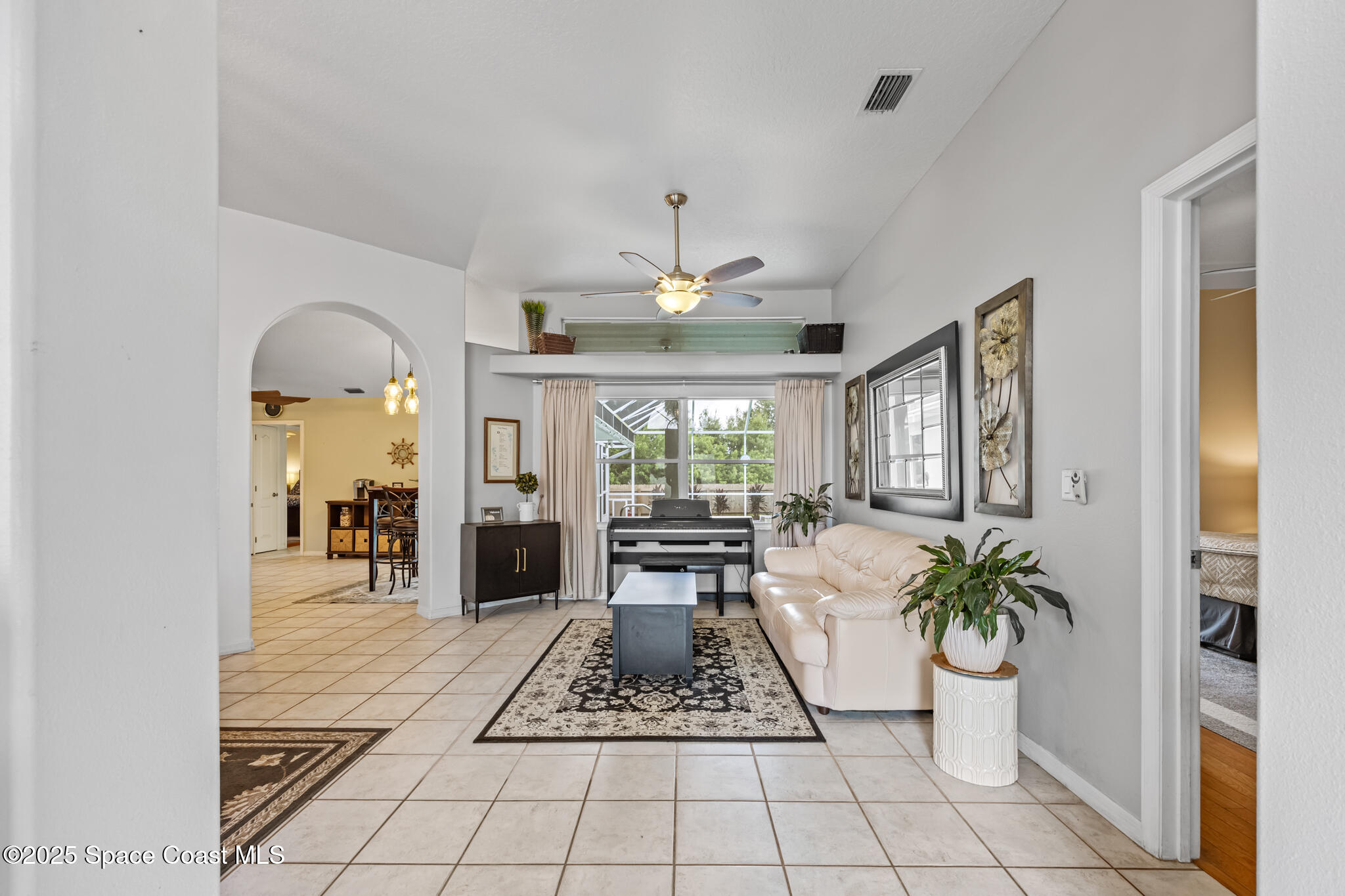 1252 Winding Meadows Road Rockledge, FL 32955 - Photo 5 of 32 a living room with furniture flowers and a fireplace
