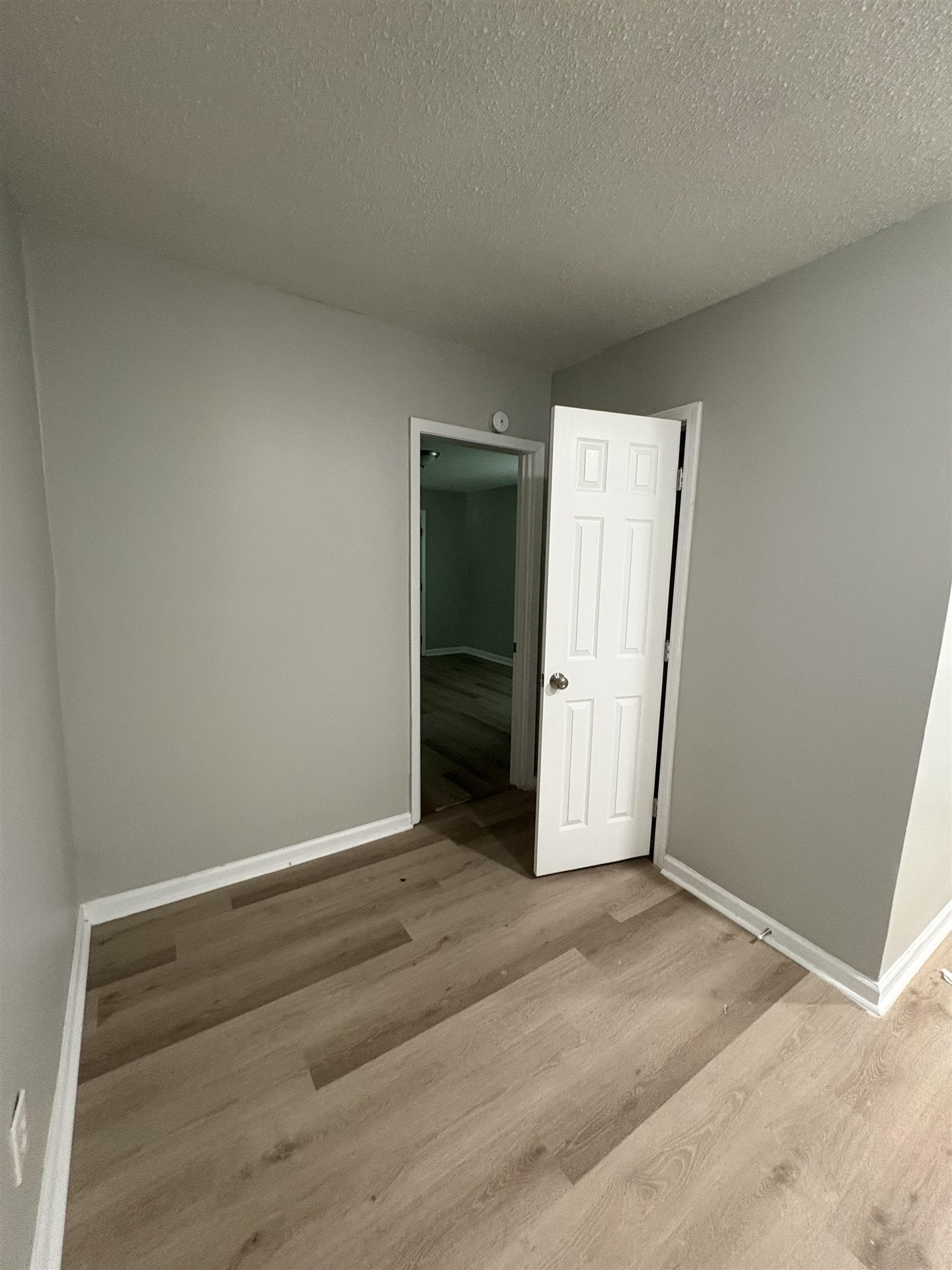 945 Nora Road Memphis, TN 38109 - Photo 11 of 27 an empty room with wooden floor and white doors