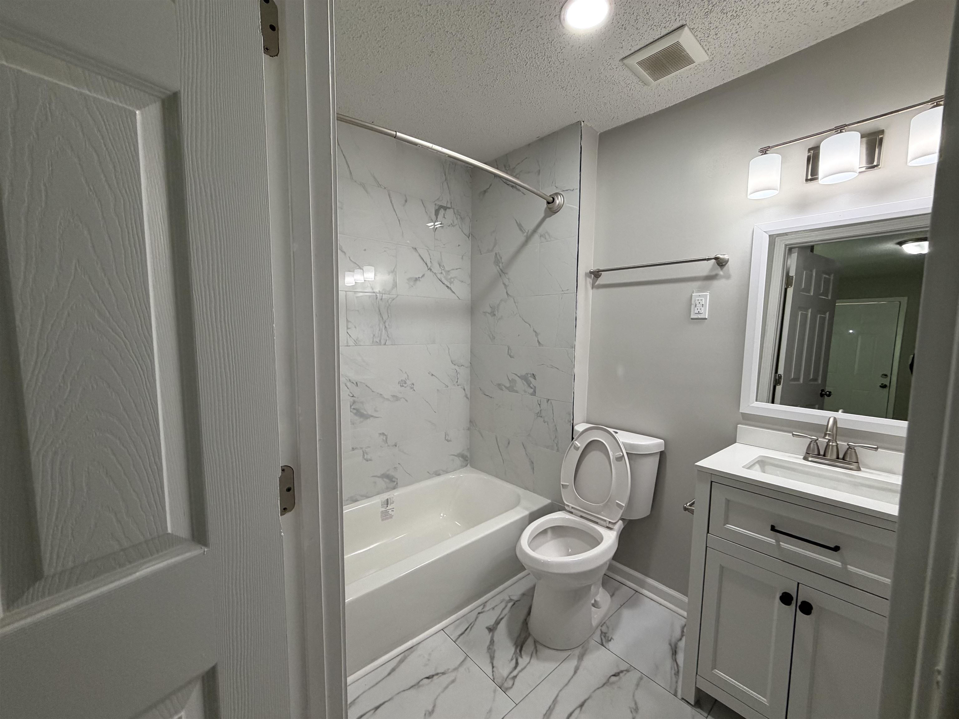 945 Nora Road Memphis, TN 38109 - Photo 20 of 27 a bathroom with a toilet a sink a mirror a bathtub and vanity