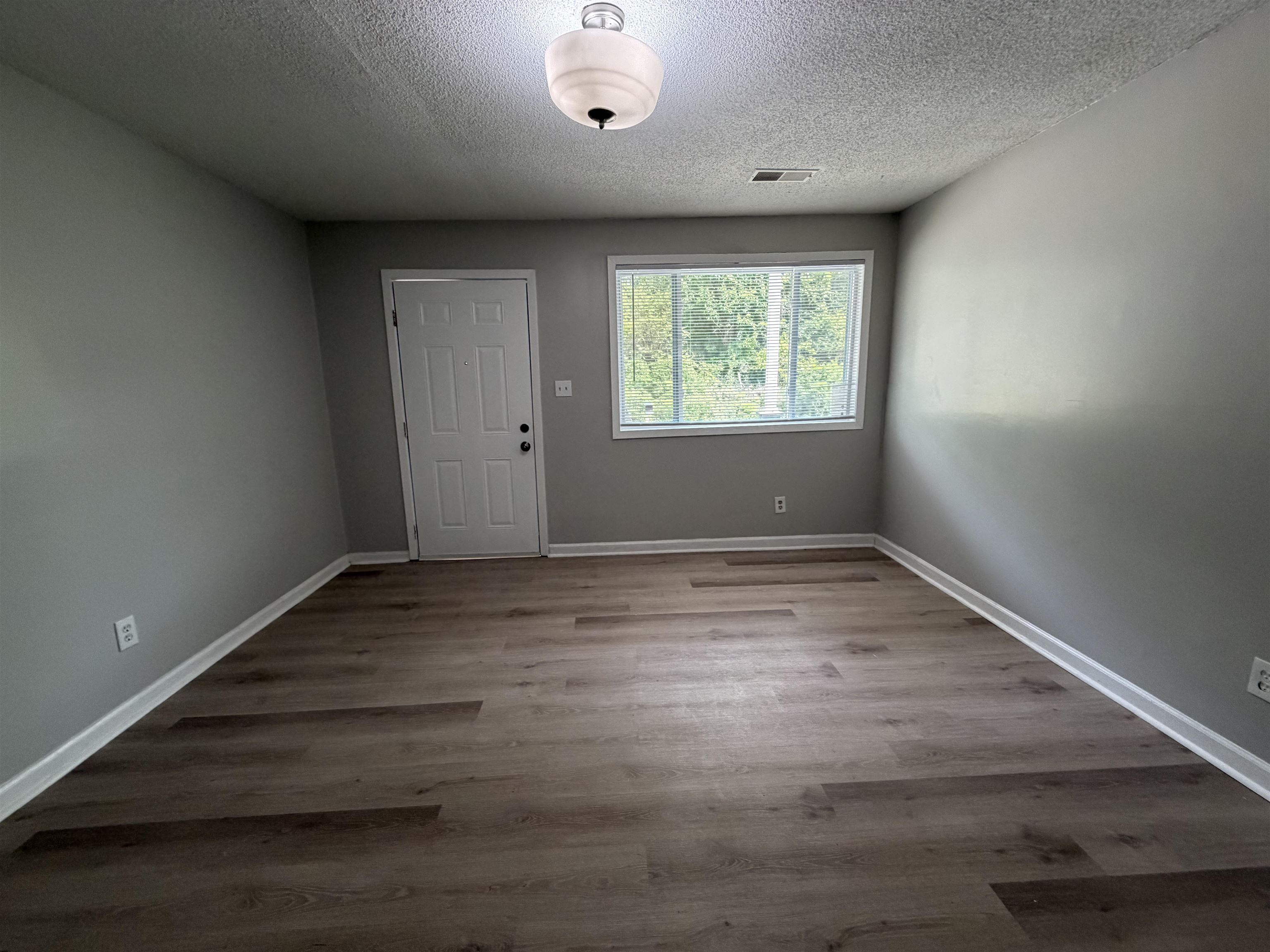 945 Nora Road Memphis, TN 38109 - Photo 22 of 27 an empty room with wooden floor and windows