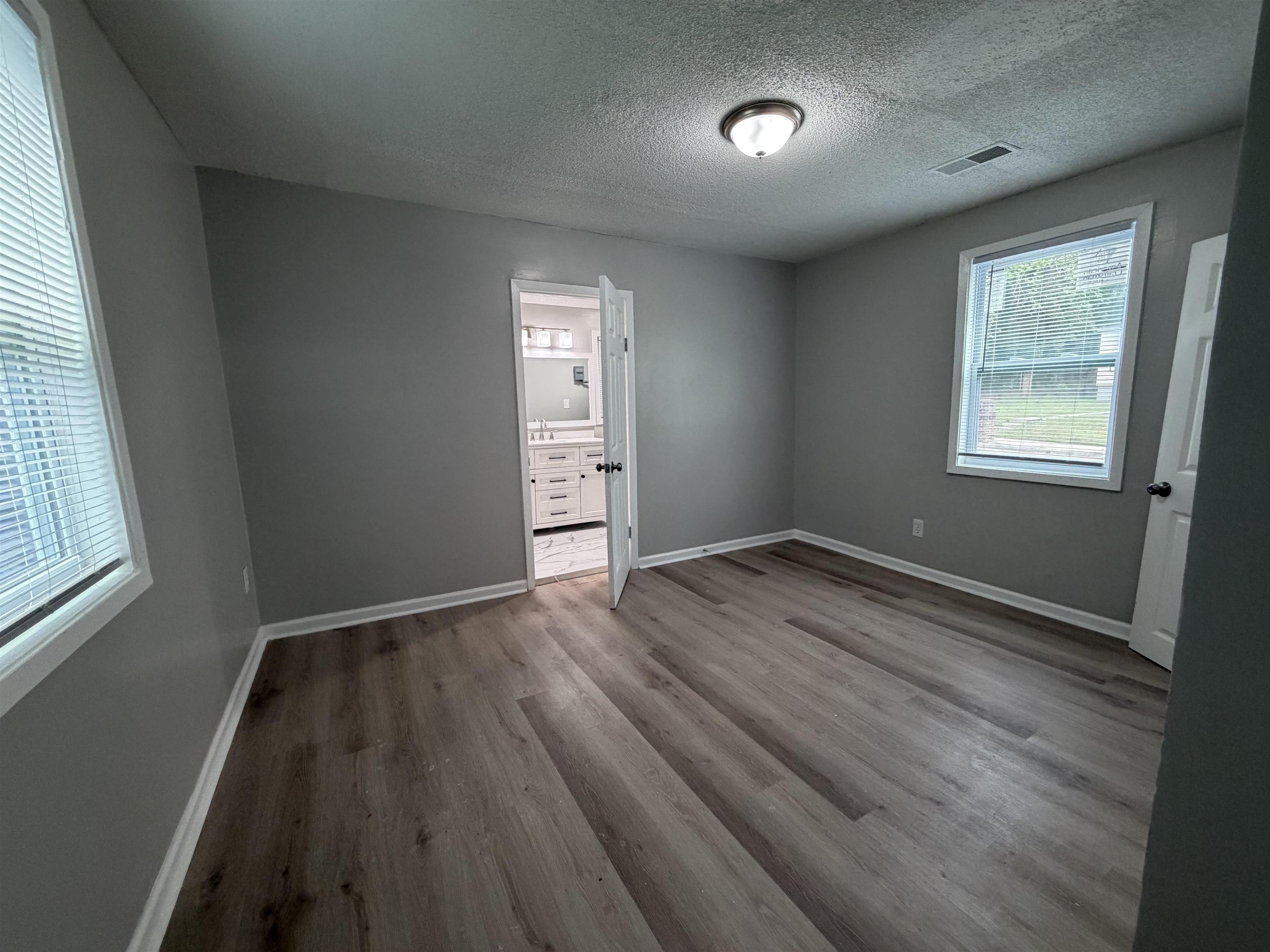 945 Nora Road Memphis, TN 38109 - Photo 8 of 27 an empty room with wooden floor and windows