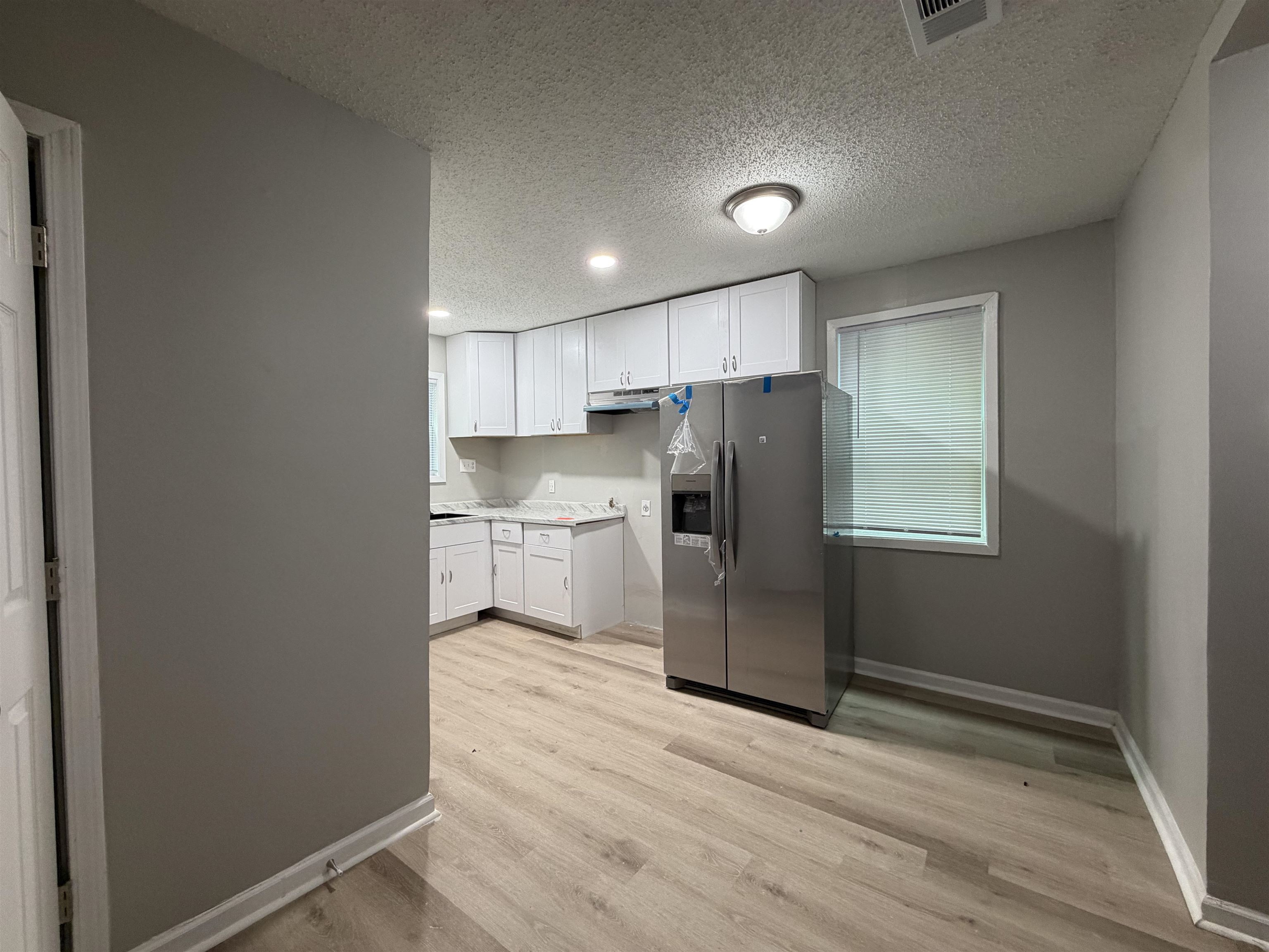 945 Nora Road Memphis, TN 38109 - Photo 10 of 27 a kitchen with stainless steel appliances a refrigerator and wooden floor