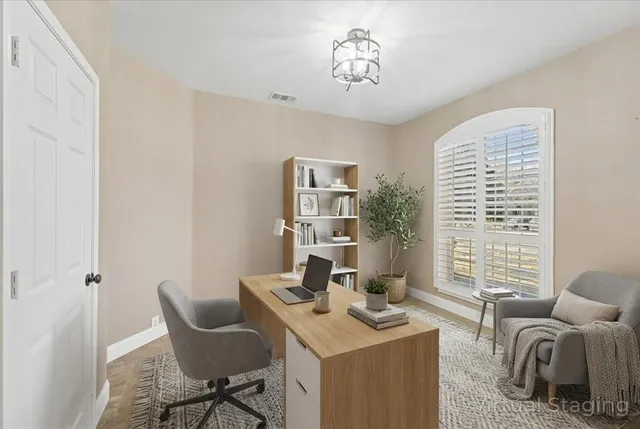 a view of a workspace with furniture and a window