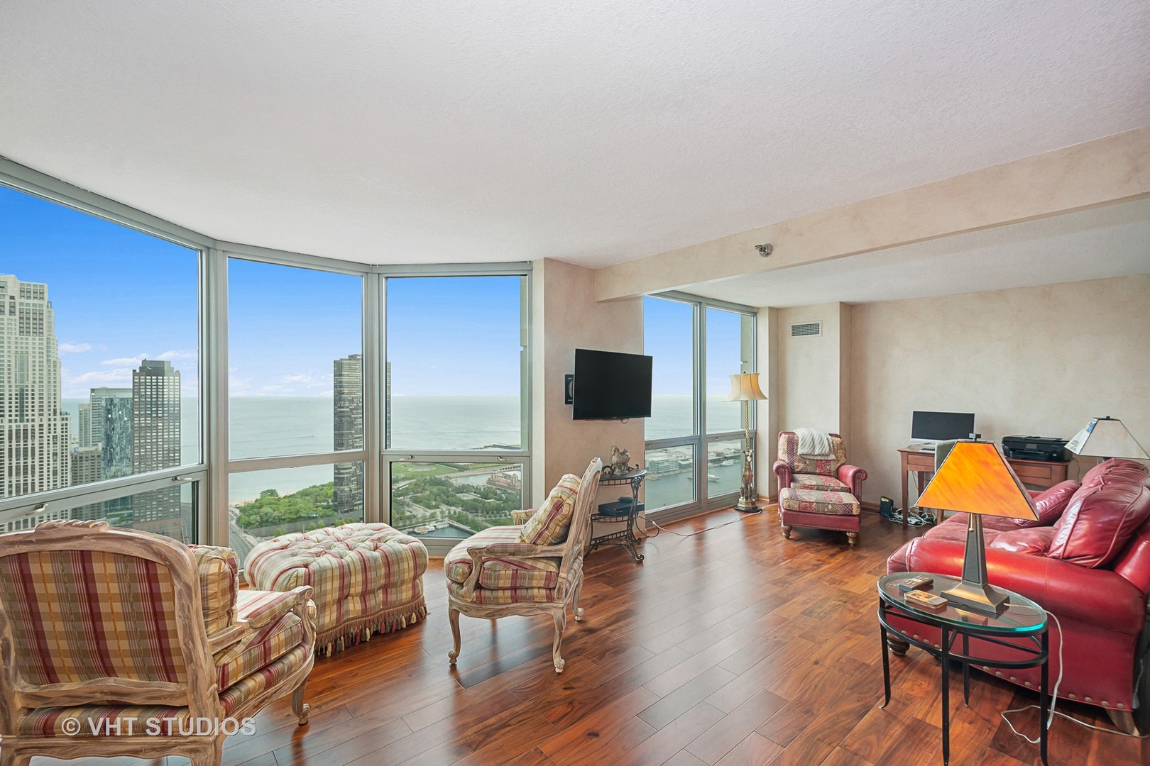195 North Harbor Drive, Unit 5201 Chicago, IL 60601 - Photo 2 of 16 a living room with furniture a flat screen tv and floor to ceiling windows