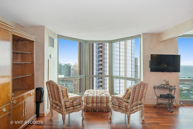 195 North Harbor Drive, Unit 5201 Chicago, IL 60601 - Photo 7 of 16 a living room with furniture a flat screen tv and floor to ceiling window