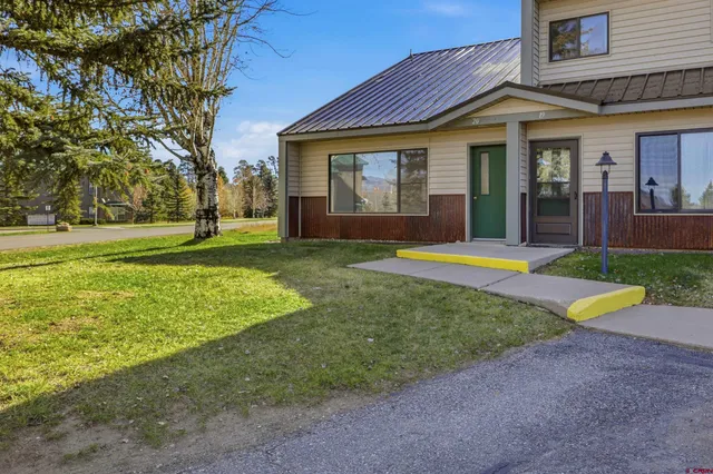 a view of a house with a yard and sitting area