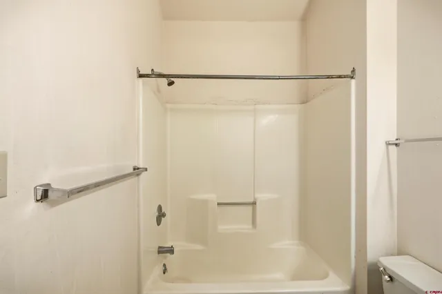 an empty room with a ceiling fan and windows