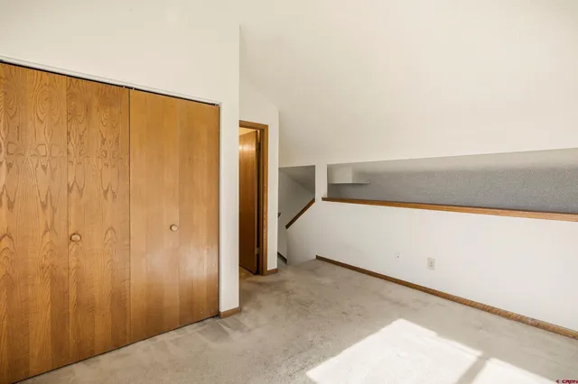 a view of an empty room with closet and a window
