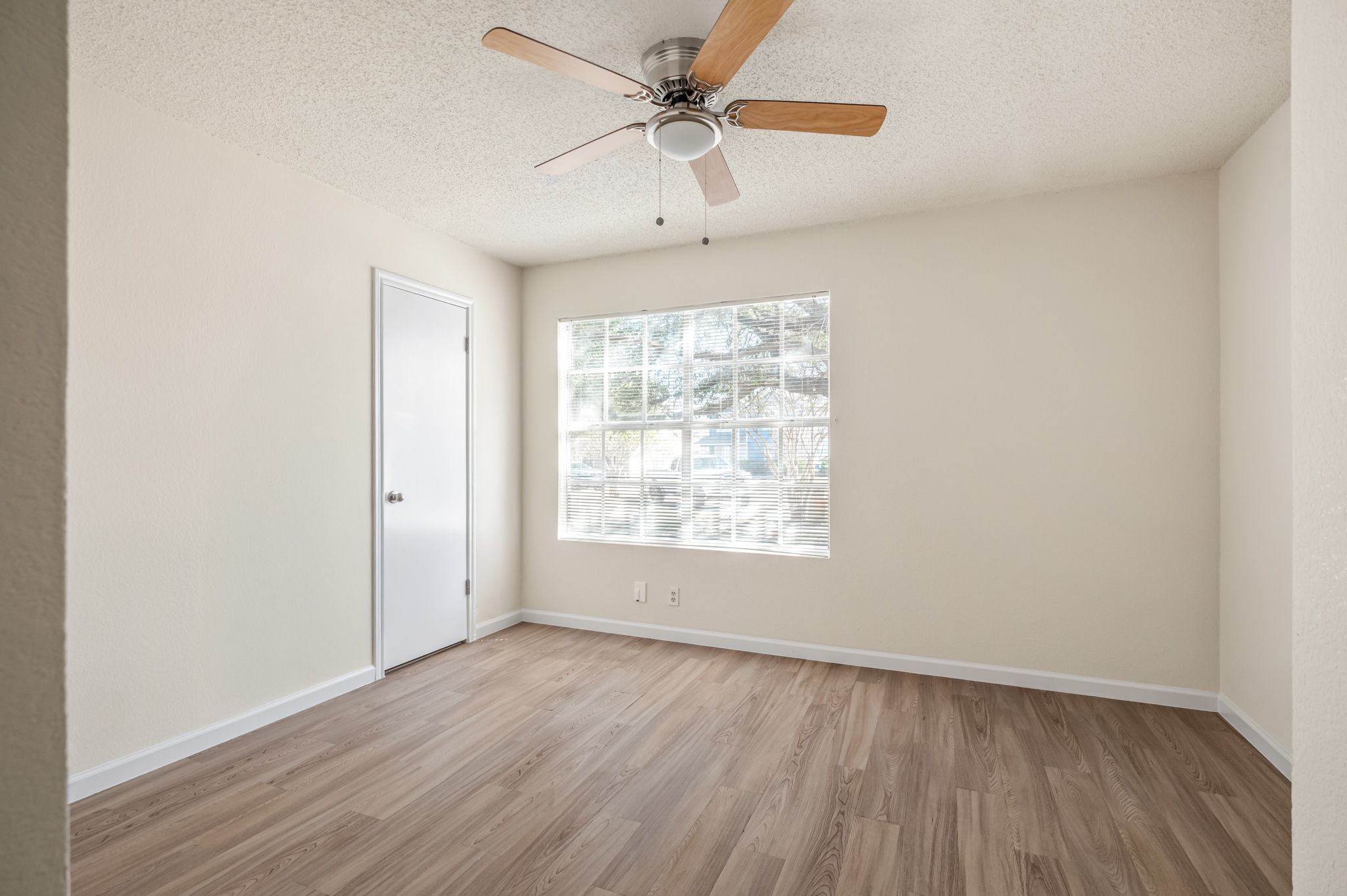 161 Segovia Way Pflugerville, TX 78660 - Photo 27 of 37 an empty room with wooden floor chandelier fan and windows