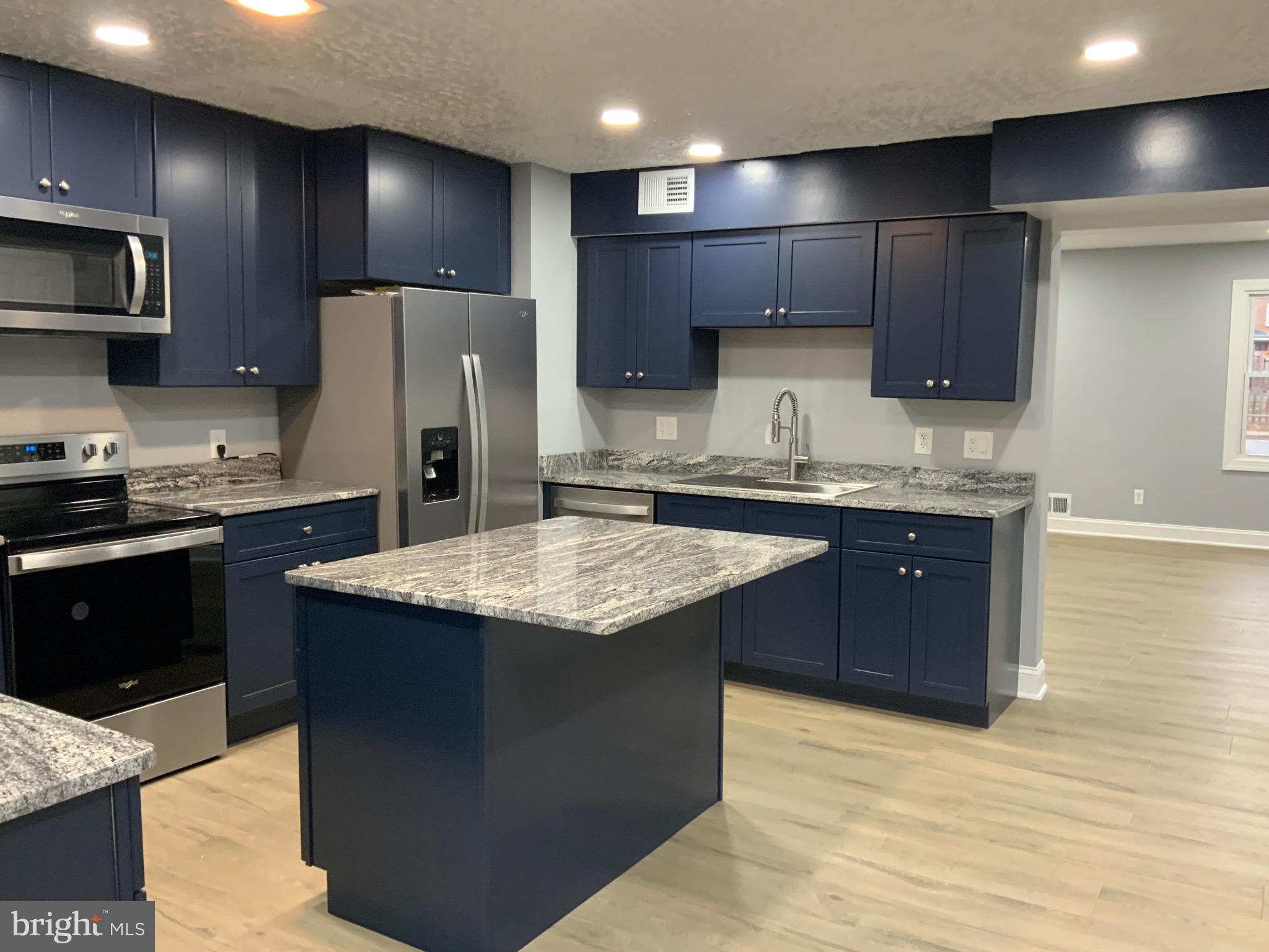 9414 Taney Road Manassas, VA 20110 - Photo 8 of 46 a kitchen with kitchen island granite countertop stainless steel appliances a sink stove refrigerator and cabinets