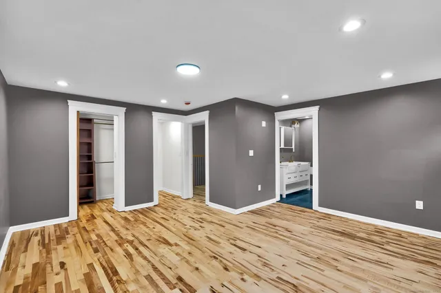 a view of a bedroom with wooden floor and bathroom