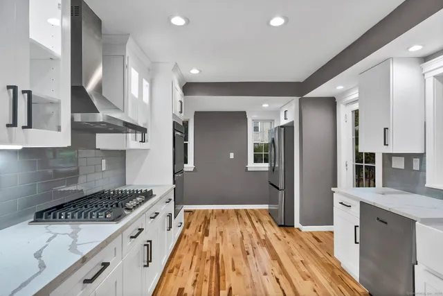 a kitchen with stainless steel appliances granite countertop a refrigerator and a sink