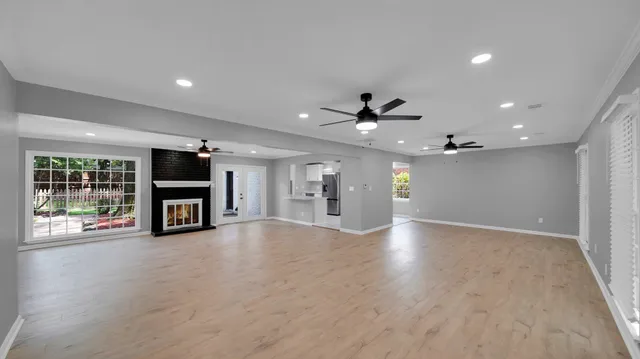 a view of an empty room with a window and fireplace