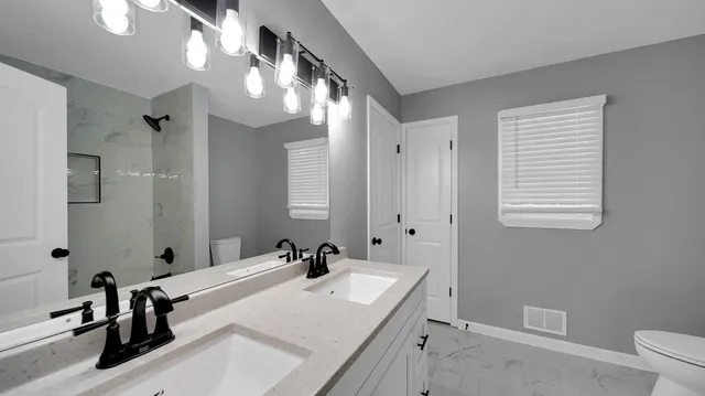 a bathroom with a sink a toilet and mirror