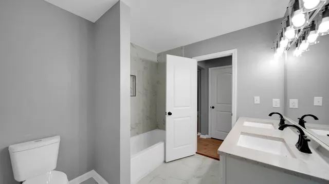 a bathroom with a sink and mirror with toilet