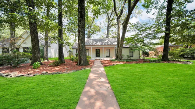 a front view of a house with a garden and patio
