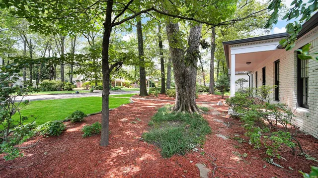 a front view of a house with a yard and an trees