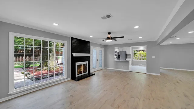 a view of an empty room with a fireplace and a window