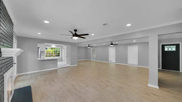 an empty room with windows and cabinet