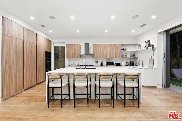 a kitchen with kitchen island a table and chairs in it