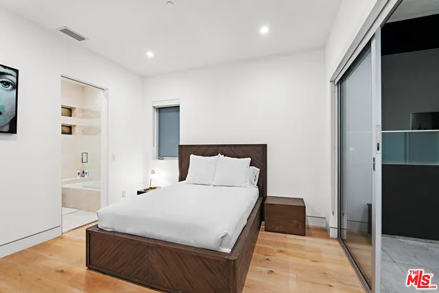 a large bedroom with a bed and wooden floor