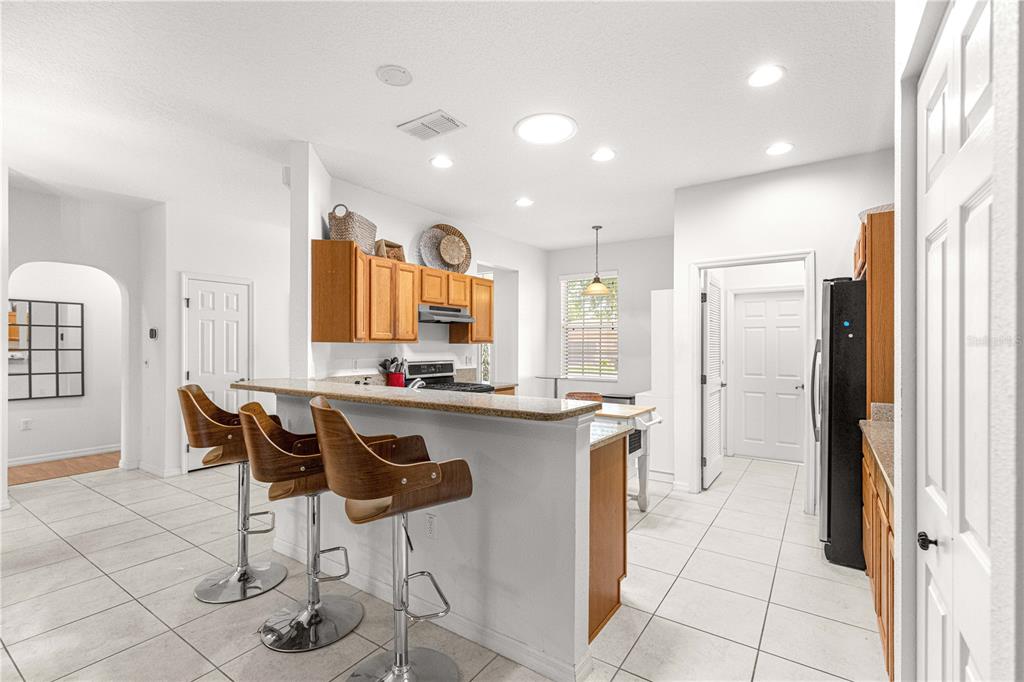 9317 Southwest 94th Loop Ocala, FL 34481 - Photo 10 of 40 a kitchen with stainless steel appliances granite countertop a sink and a refrigerator