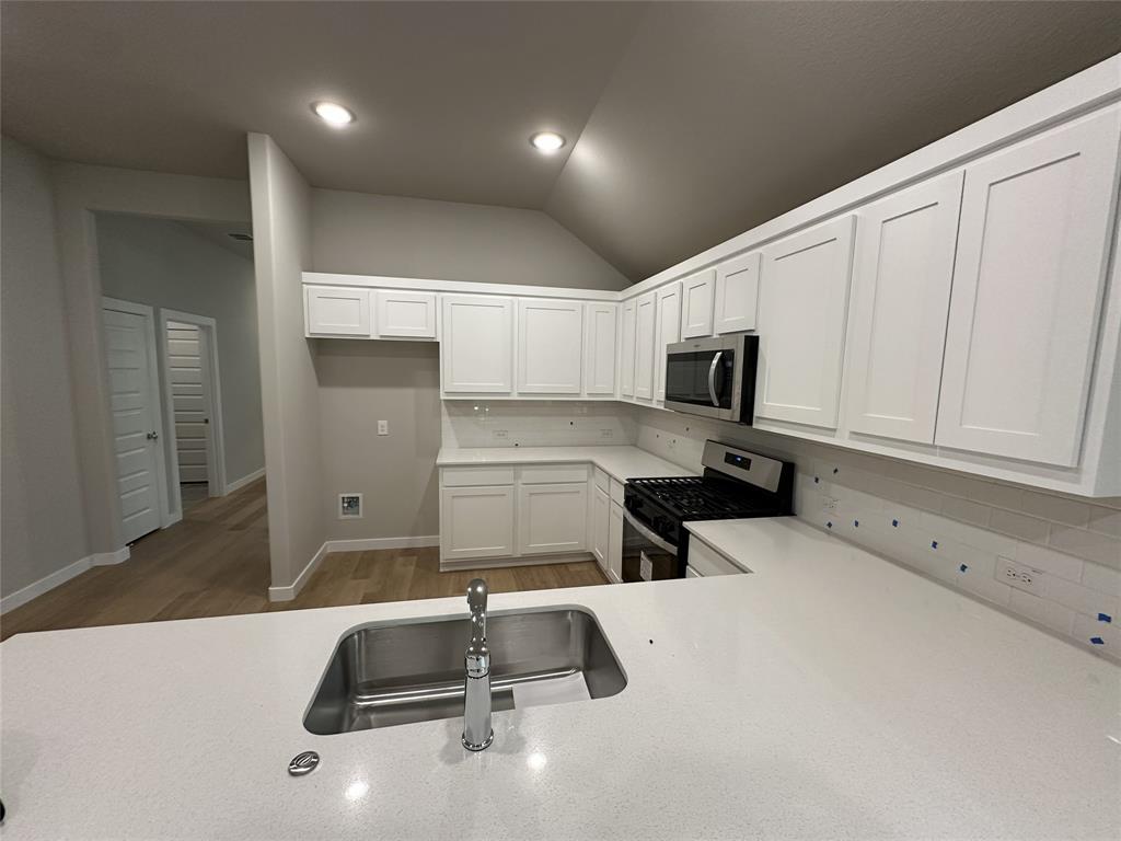 109 Lavender Street Forney, TX 75126 - Photo 11 of 15 a kitchen with a sink a microwave and cabinets