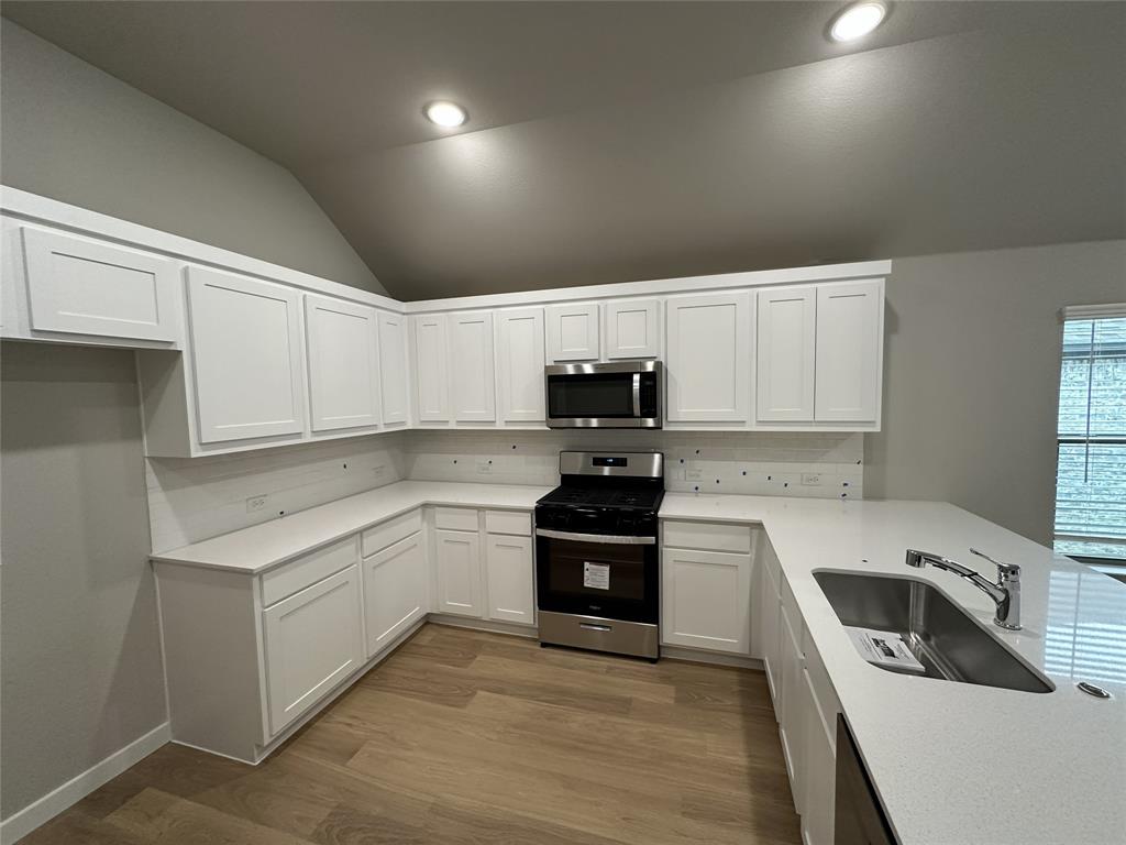 109 Lavender Street Forney, TX 75126 - Photo 12 of 15 a kitchen with stainless steel appliances granite countertop a stove a sink and a refrigerator