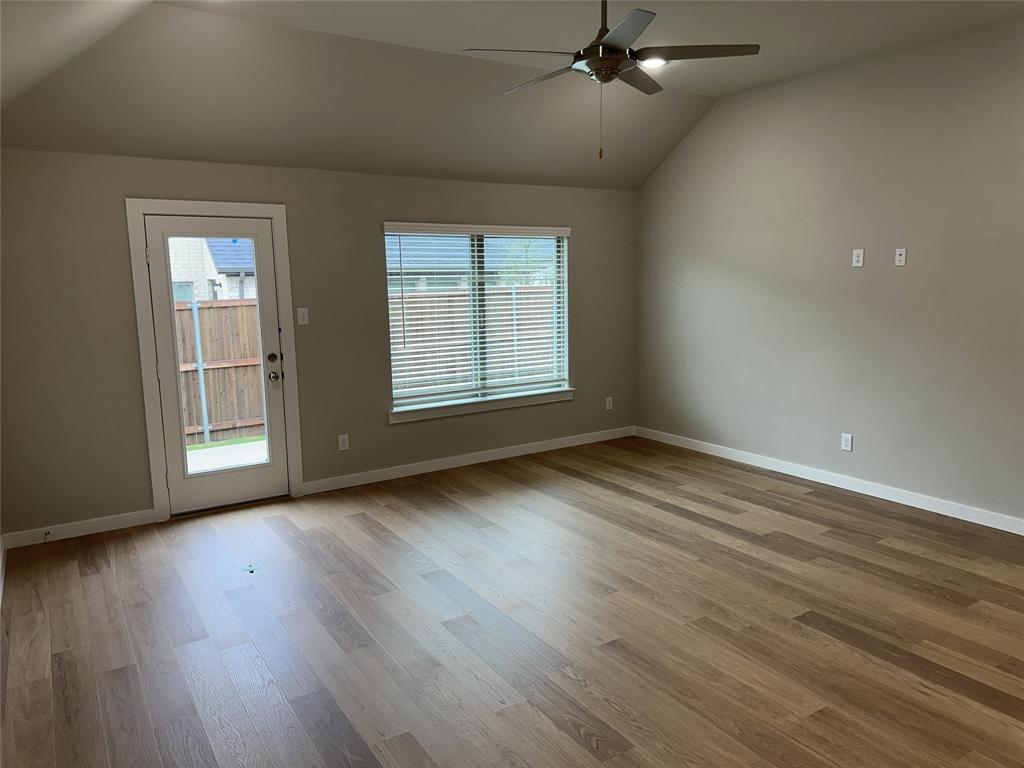109 Lavender Street Forney, TX 75126 - Photo 9 of 15 an empty room with wooden floor cabinet and windows