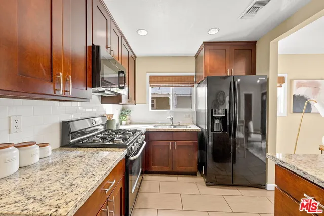 a kitchen with stainless steel appliances granite countertop a refrigerator stove and oven
