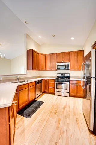 a large kitchen with stainless steel appliances kitchen island granite countertop a large counter top and a view of living room
