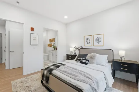a bedroom with a bed and wooden floor