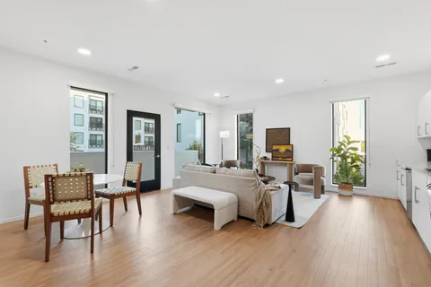 a living room with furniture flat screen tv and wooden floor