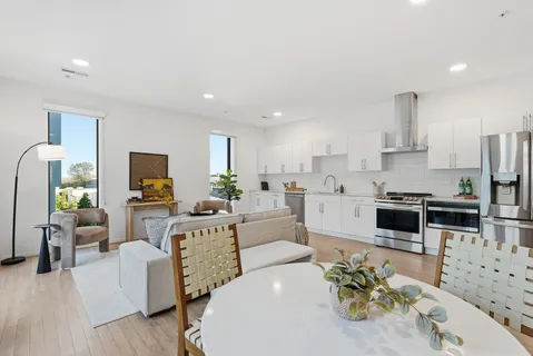 a large white kitchen with stainless steel appliances