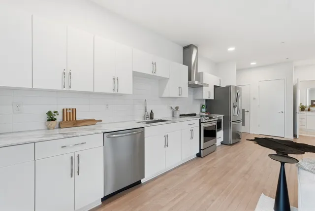 a kitchen with white cabinets and appliances