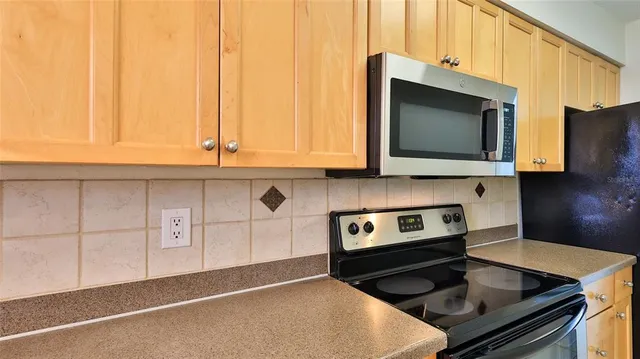 a kitchen with stainless steel appliances granite countertop a stove a microwave and cabinets