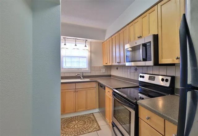 a kitchen with stainless steel appliances granite countertop a sink stove and microwave