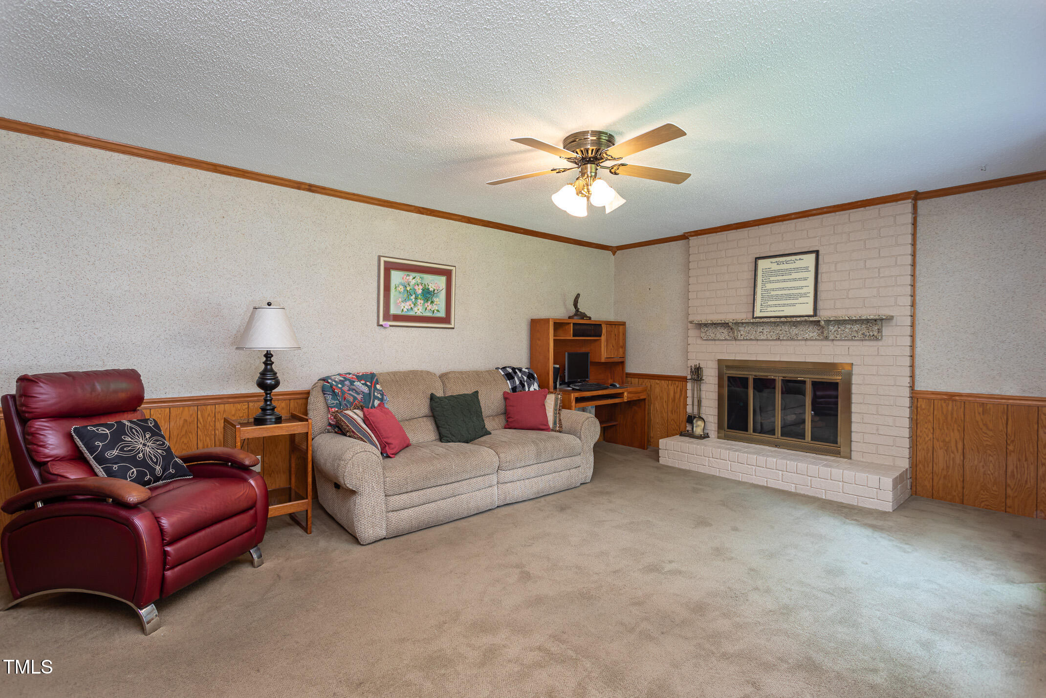 1213 Indian Trail Drive Raleigh, NC 27609 - Photo 12 of 50 a living room with furniture a fireplace and a ceiling fan