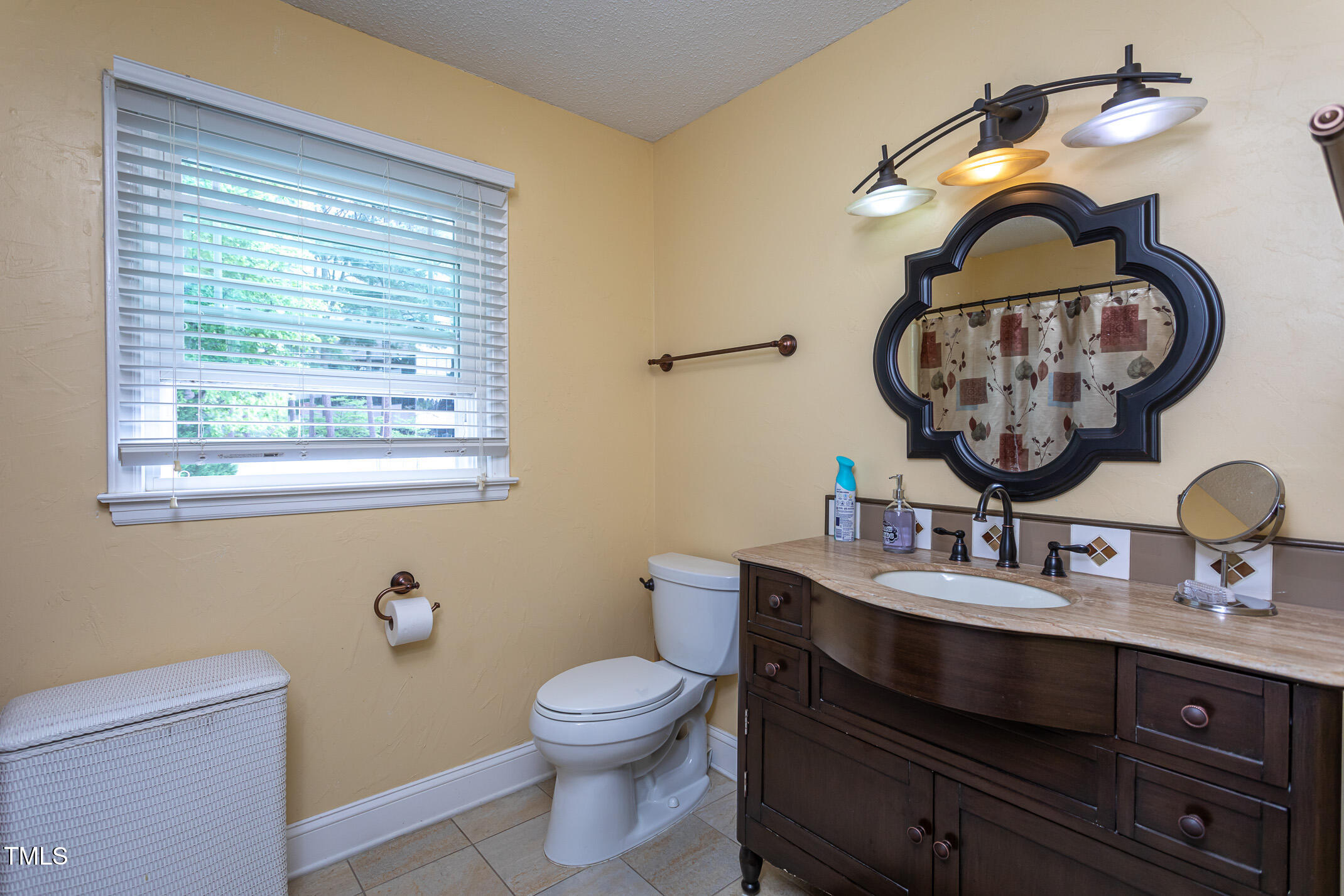 1213 Indian Trail Drive Raleigh, NC 27609 - Photo 27 of 50 a bathroom with a toilet a sink and mirror