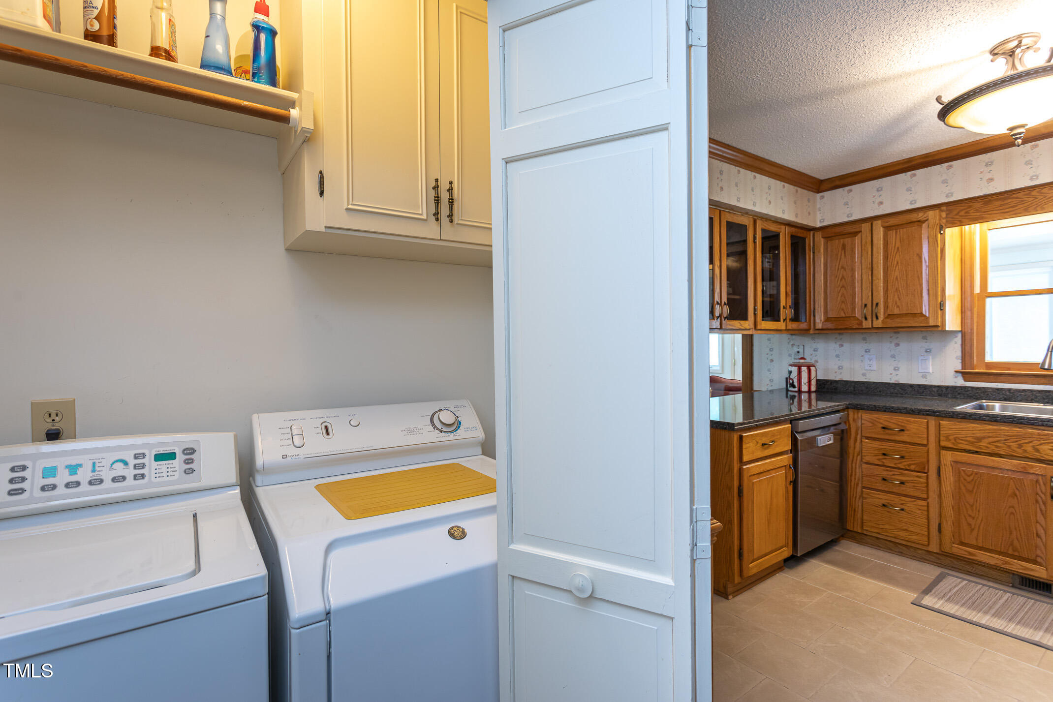 1213 Indian Trail Drive Raleigh, NC 27609 - Photo 10 of 50 a view of washer and dryer with kitchen in the background