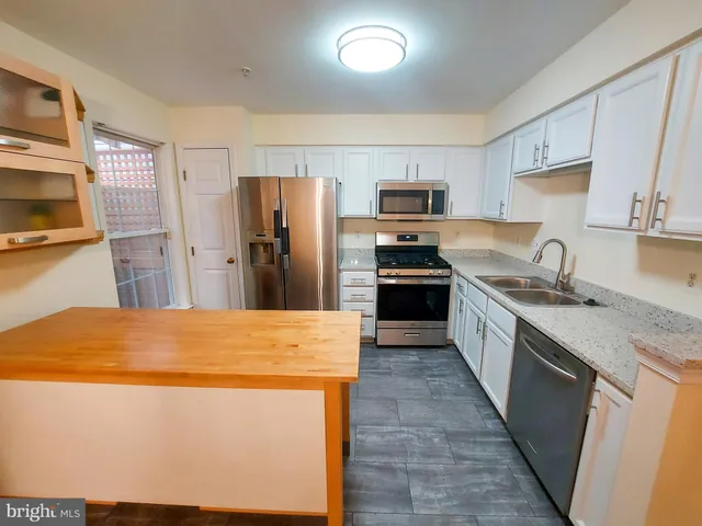 a kitchen with stainless steel appliances a refrigerator stove microwave and sink